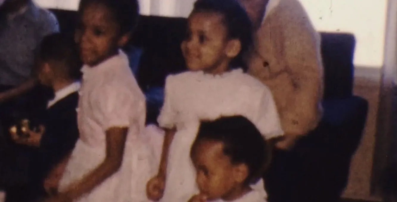 three young children are seen dancing in a dimly lit family room in the 1960s.