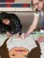 a school-aged child draws a larger than life character alongside an art instructor