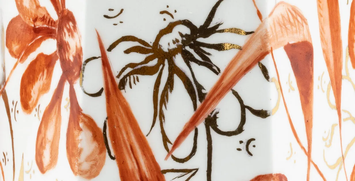 a close up image of a handpainted china vase, showing delicate flowers and brushstrokes