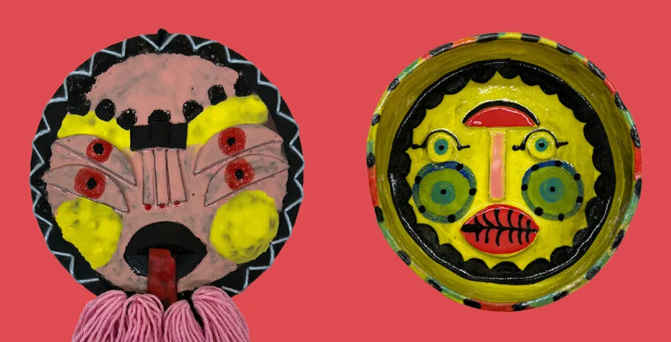 two ceramic faces appear on a red background. the faces have vibrant and graphic features in red, pink, and yellow. The left face has tassels hanging from its chin.